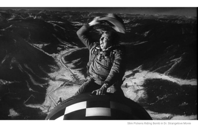 A man riding a bomb like a horse, waving his hat above his head