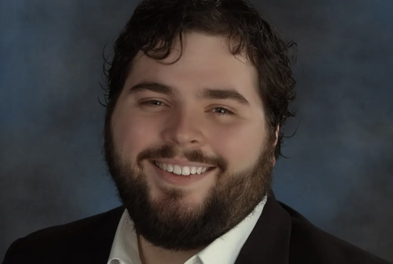 Jonathan Elmore A headshot of tenor Jonathan Elmore, a man with dark hair, a short beard, smiling.
